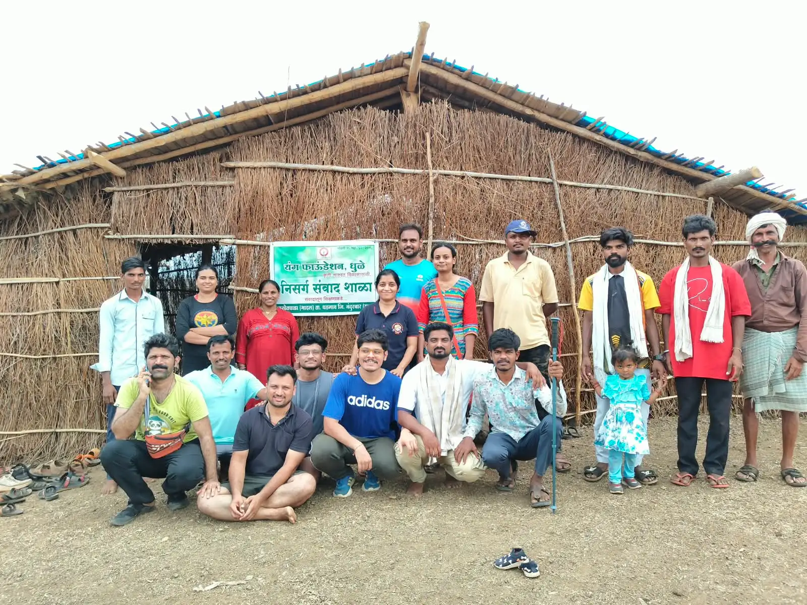 यंग फाऊंडेशनचे कार्यकर्ते आणि ग्रामस्थ सातपुड्यातील एका घरासमोर उभे आहेत.