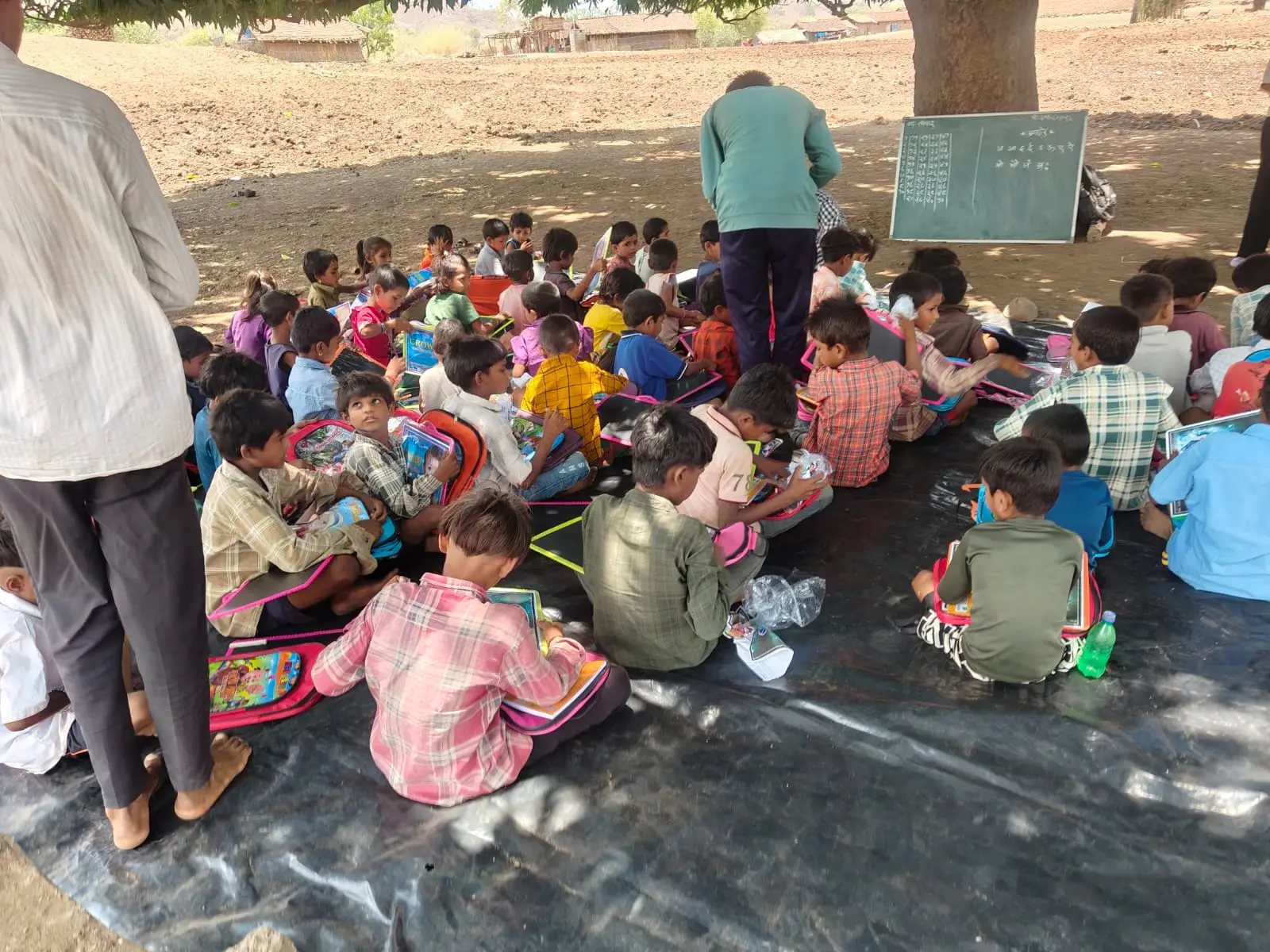 यंग फाऊंडेशनच्या सापुडा भागातील खुल्या शाळेत मुले झाडाखाली जमिनीवर बसून शिकत आहेत.