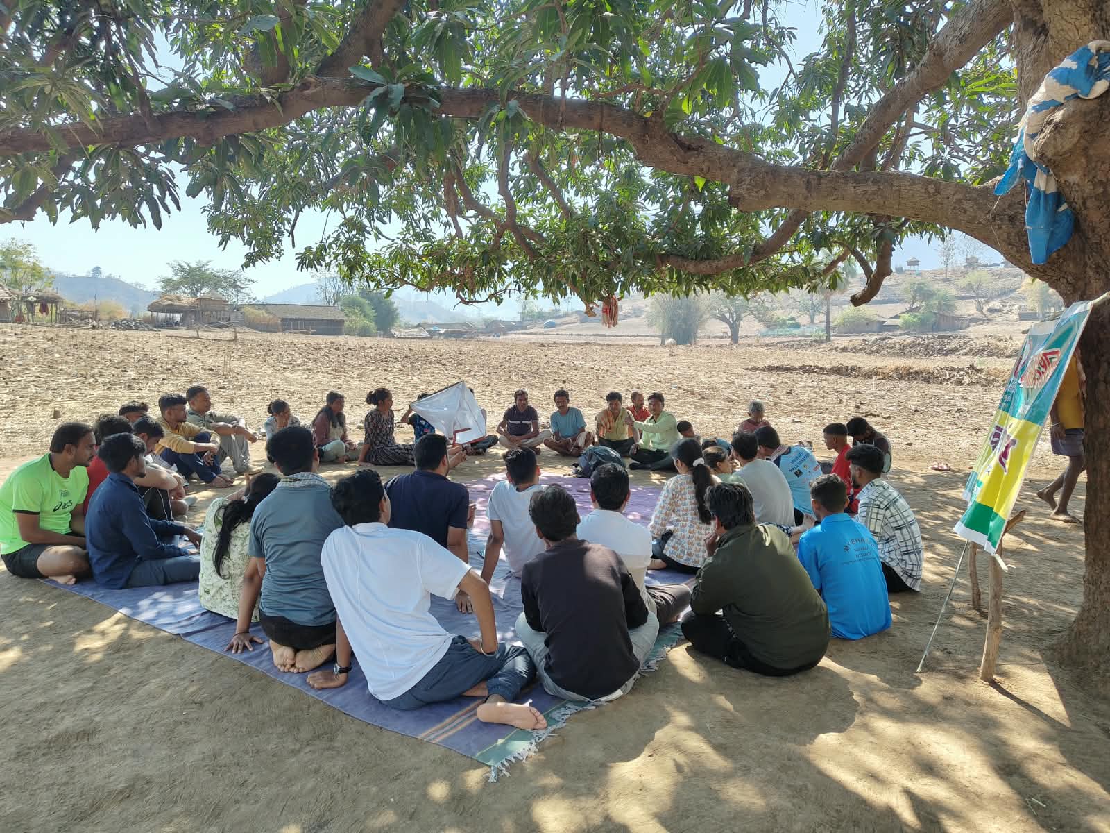सातपुडा भागातील झाडाखाली बसलेली लोकांची बैठक.