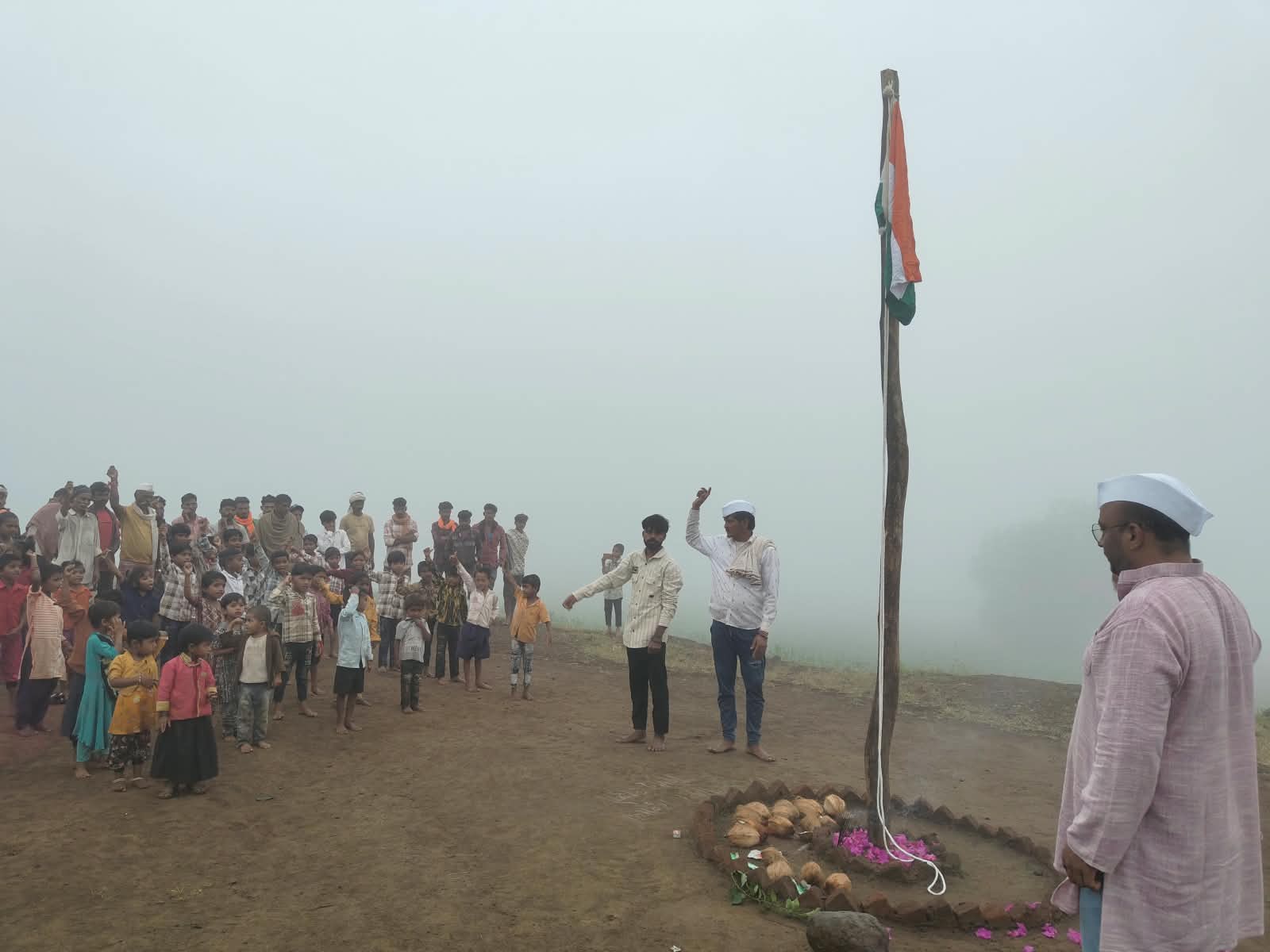 सातपुड्यातील धुके असलेल्या वातावरणात ध्वजारोहण करताना लोक.