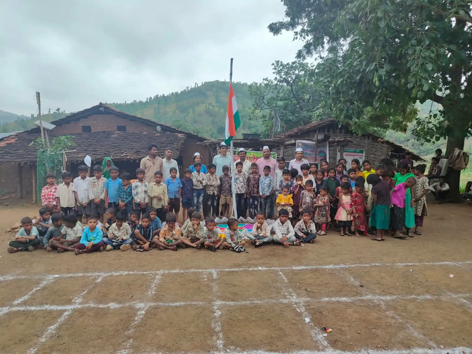 यंग फाऊंडेशनच्या कार्यक्रमात मुले, ग्रामस्थ आणि कार्यकर्ते एकत्र उभे आहेत.
