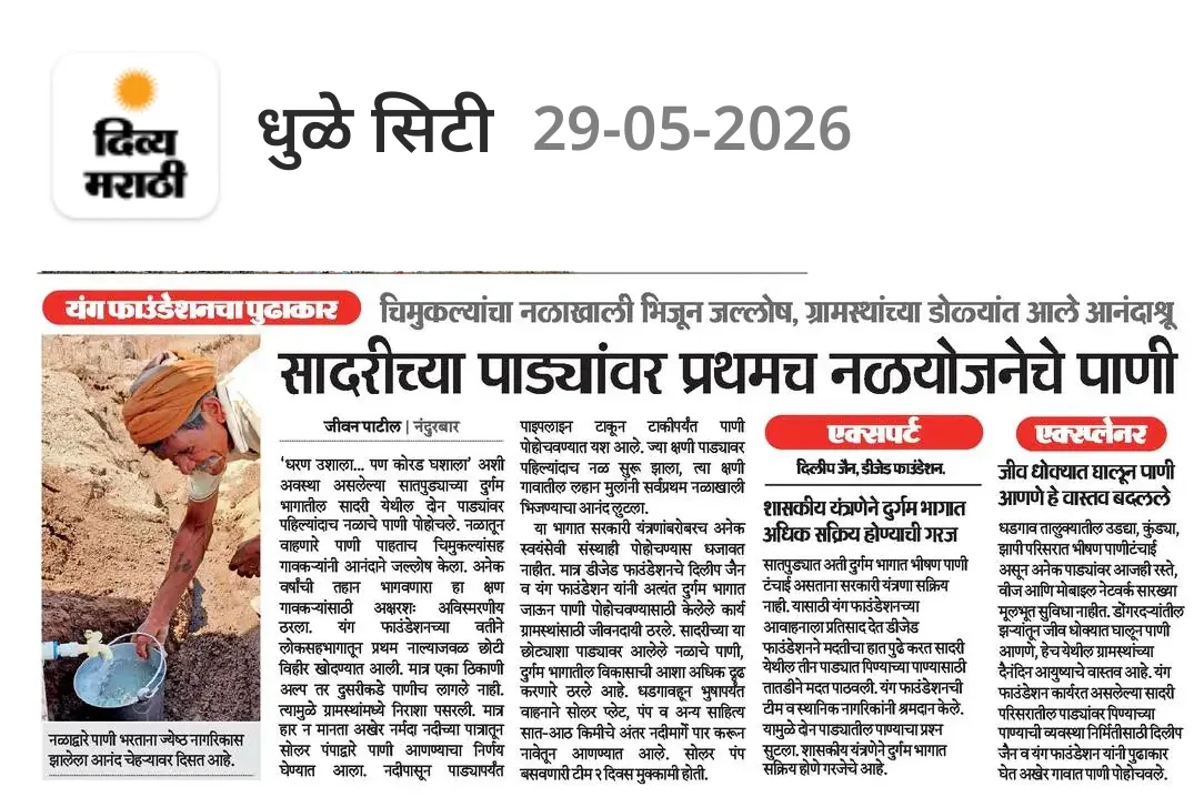 एक व्यक्ती मातीमध्ये बसून पाईपमधून बकेटमध्ये पाणी भरत आहे.