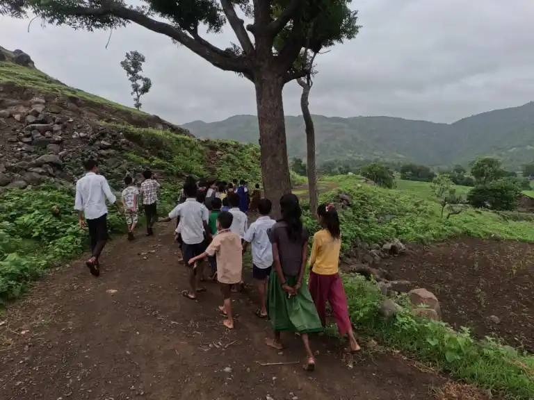 यंग फाऊंडेशनचे लोक आणि मुले सातपुडा डोंगरातील मातीच्या वाटेवर चालत आहेत.