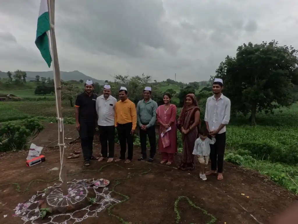 सतपुडा डोंगरांच्या पार्श्वभूमीवर ध्वजवंदनानंतर उभे असलेले लोक.