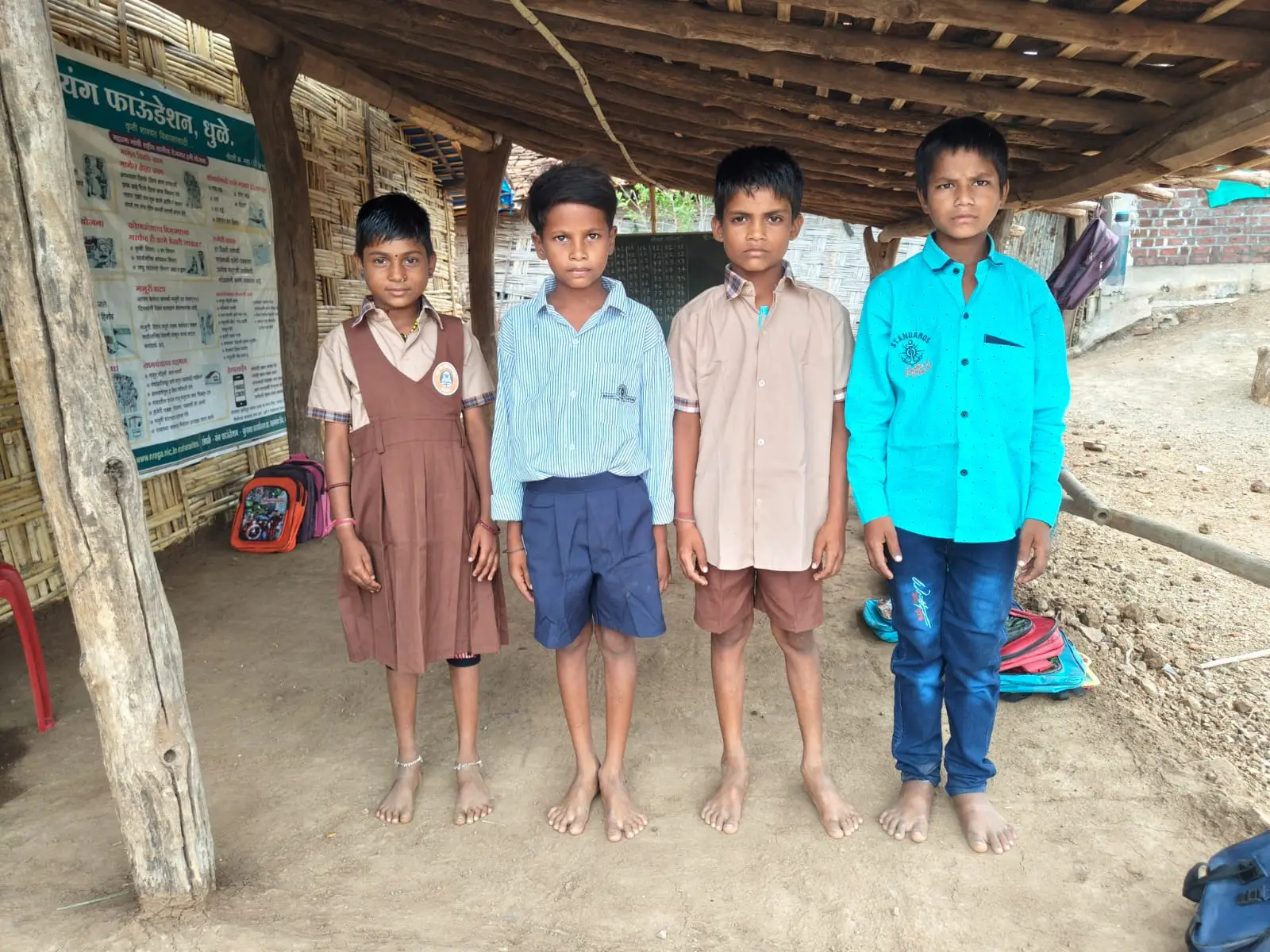 चार मुले यंग फाऊंडेशनच्या केंद्राबाहेर उभी आहेत.