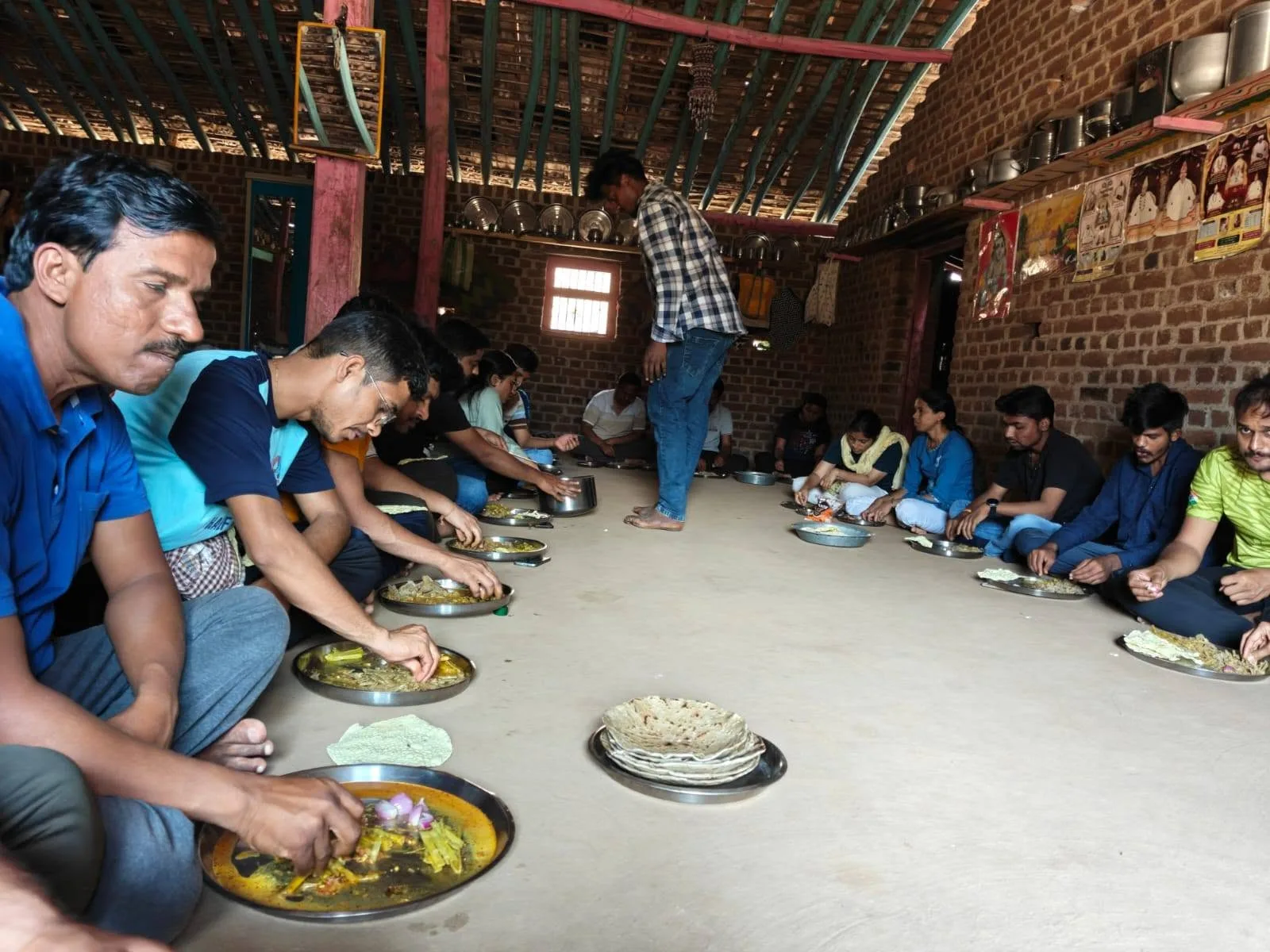 सतपुडा डोंगरांवरील एका घरात लोक एकत्र जेवत आहेत.